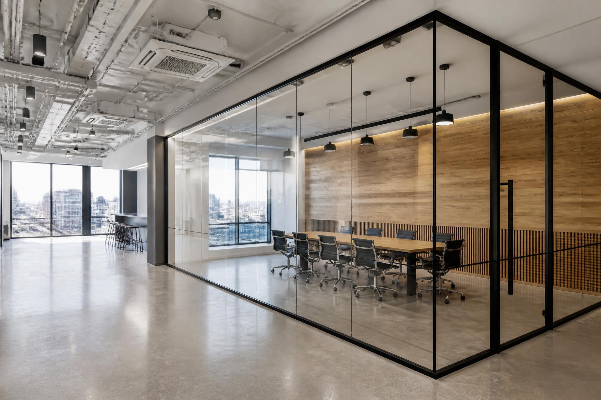 Completed London commercial office fit-out with black-framed glass partitioning, polished concrete floor and timber accent wall