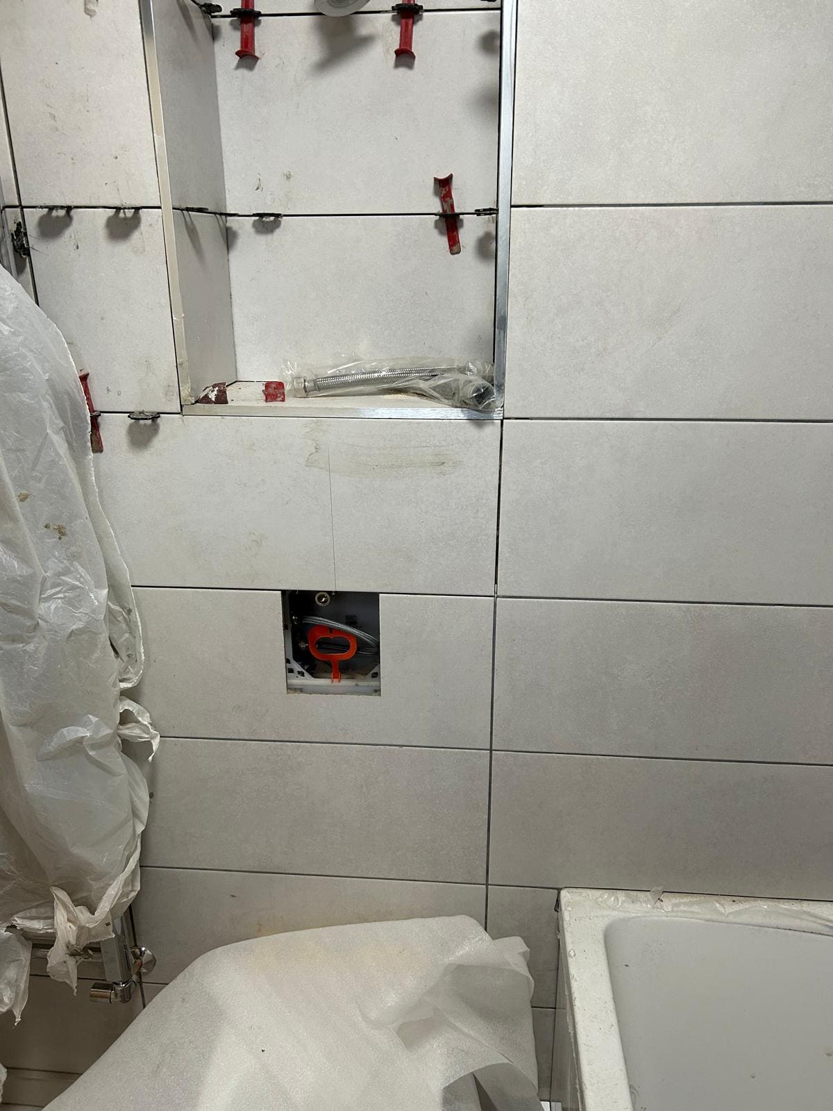 Bathroom in a London home with white metro tiles and concealed cistern first-fix in progress