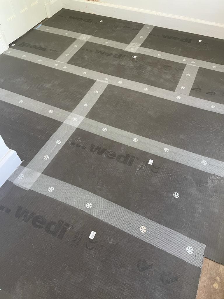 Bathroom floor waterproofing with Wedi tanking boards before tiling in a London property by Refurb Squad